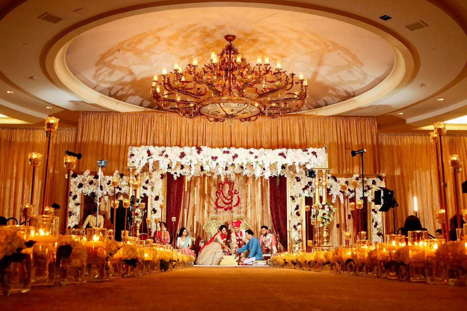 Wedding mandap set up in a chandelier-lit ballroom