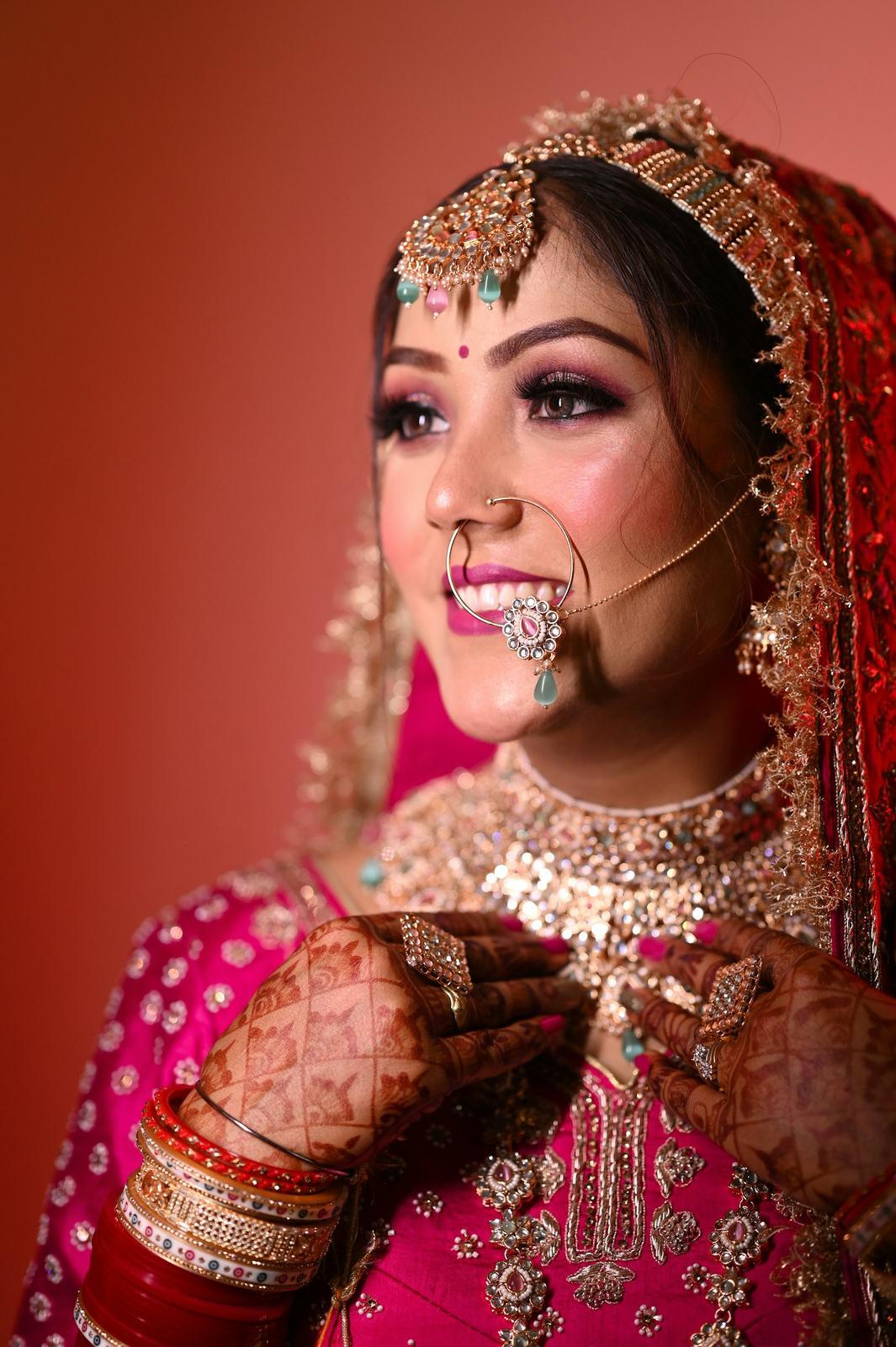 Bride in a pink lehenga with mehendi, smiling