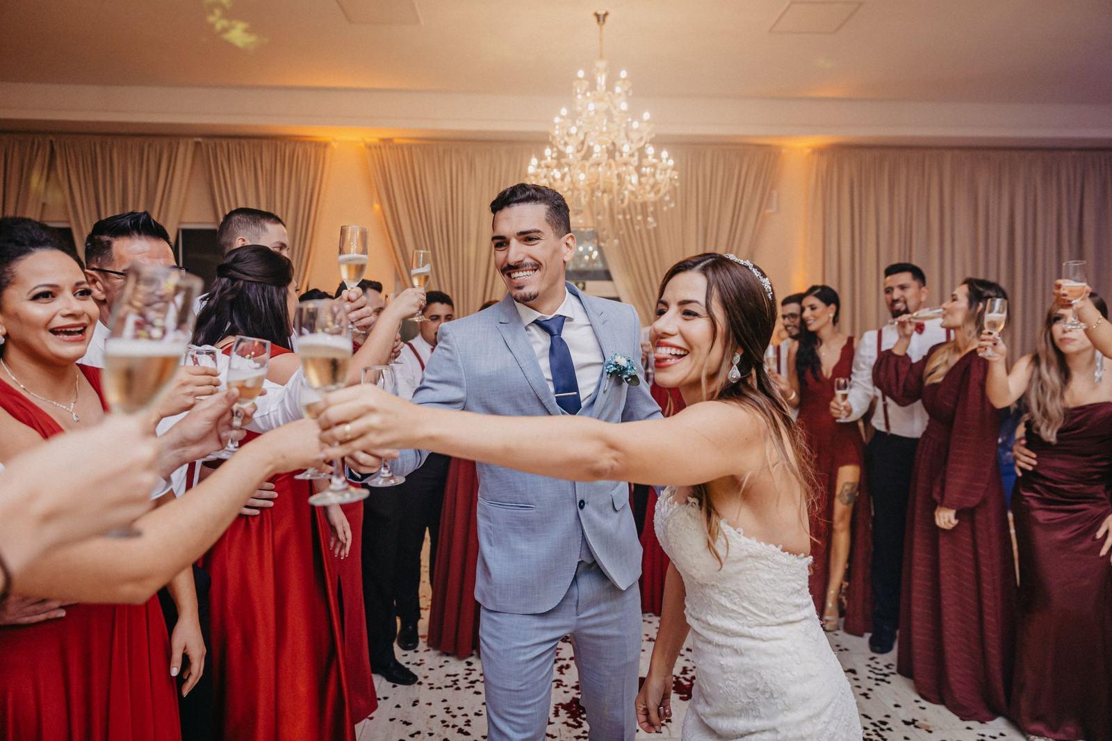 Wedding guests raising a toast in a chandelier ballroom