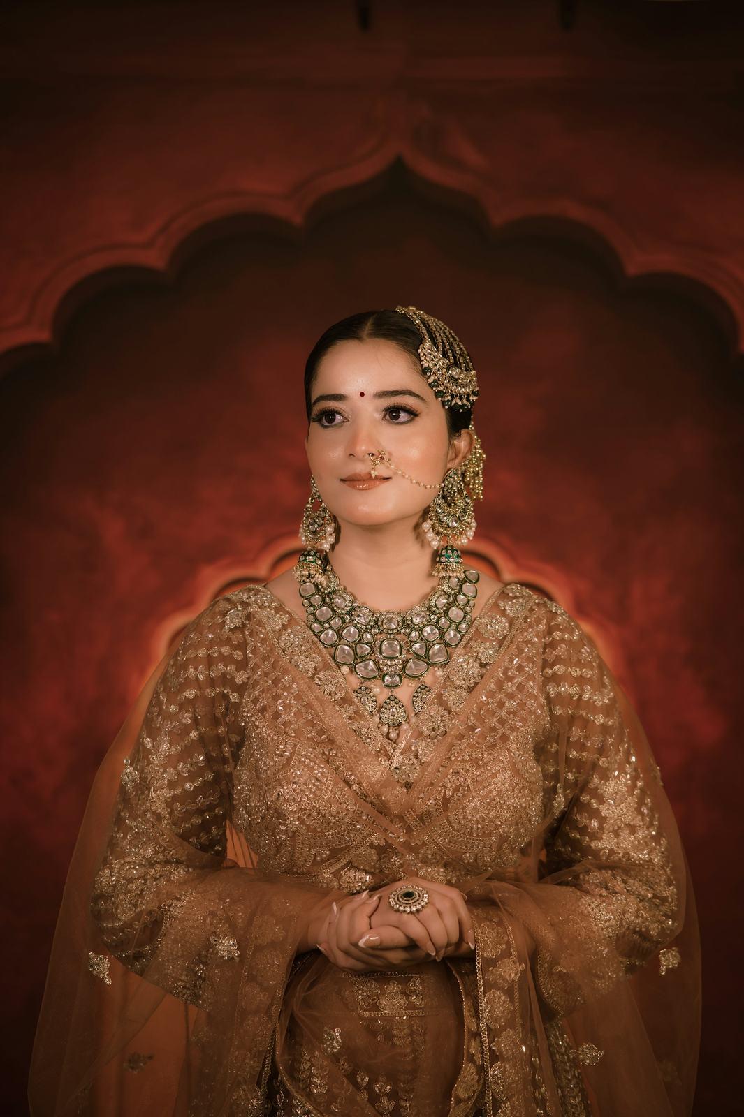 Bride in a gold lehenga with hands folded