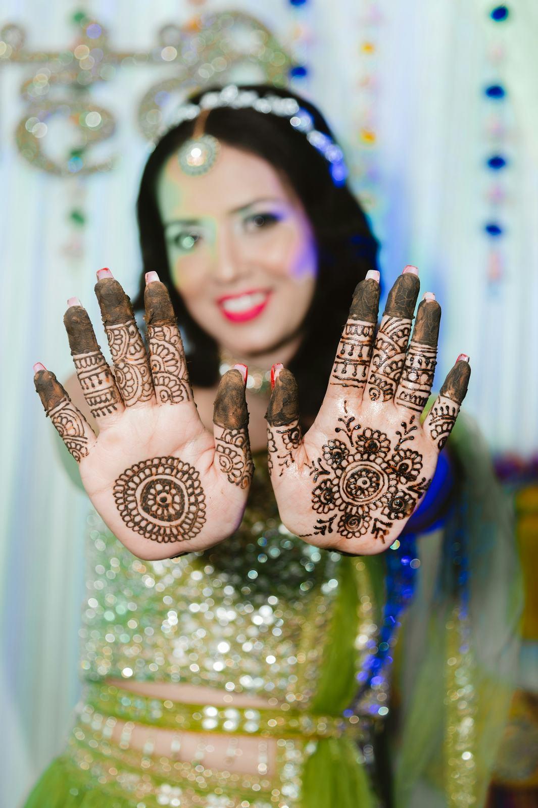 Bride holding up both hands covered in mehendi