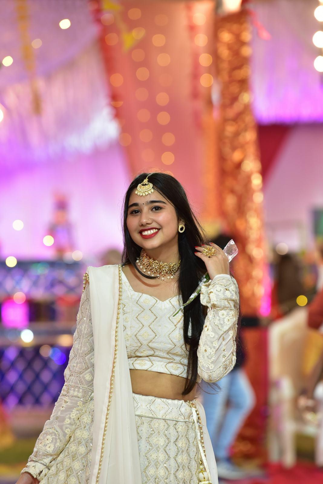 Guest in an ivory lehenga smiling at the camera