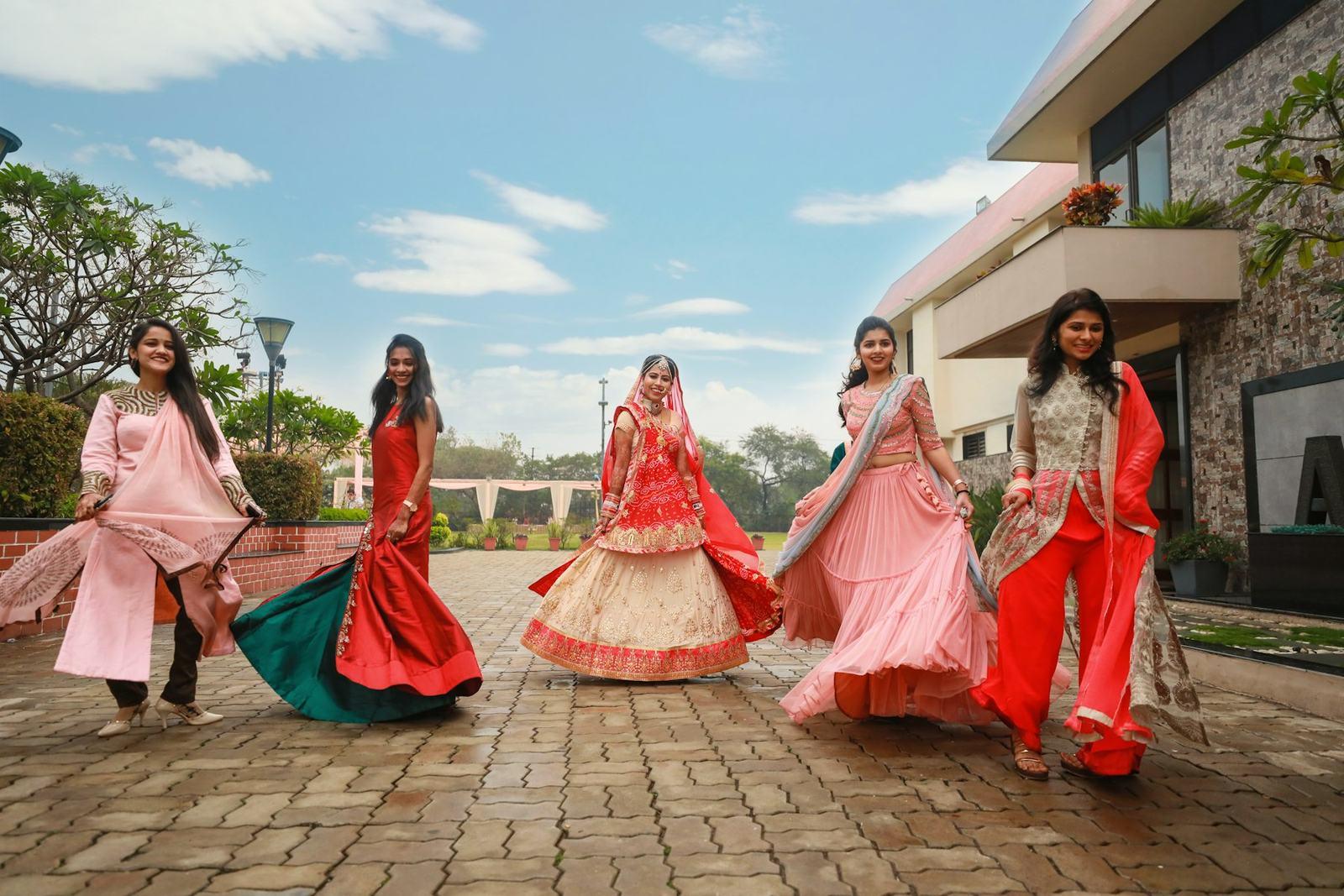 Bridesmaids in pastel lehengas twirling on a terrace