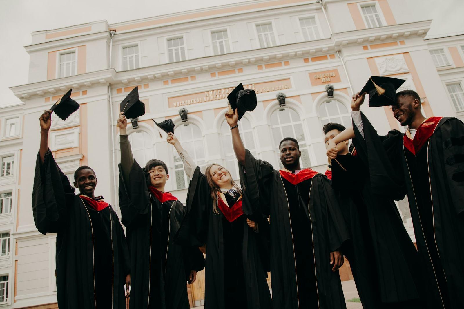 Graduates in gowns throwing their caps in the air